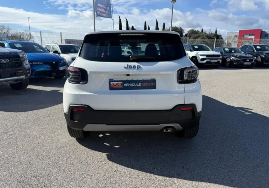 Vue arrière d’un Jeep Avenger blanc 2025 avec feux arrière fumés et pare-chocs noir contrastant.