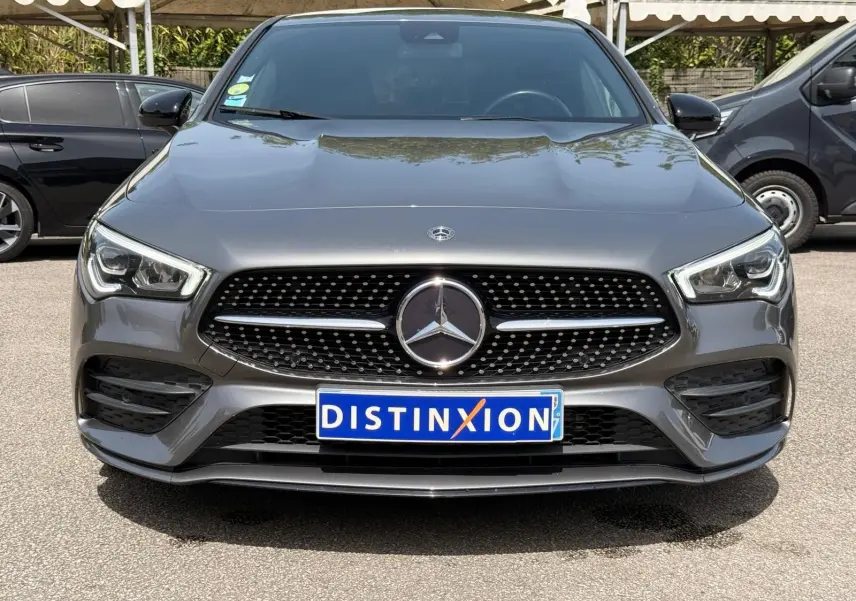 Vue avant d'une Mercedes Classe CLA 180 D AMG Line gris montagne avec calandre noire à motifs diamantés et logo central.