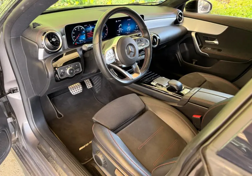 Vue intérieure côté conducteur de la Mercedes Classe CLA 180 D AMG Line 2019, avec volant sport et finitions cuir noir.