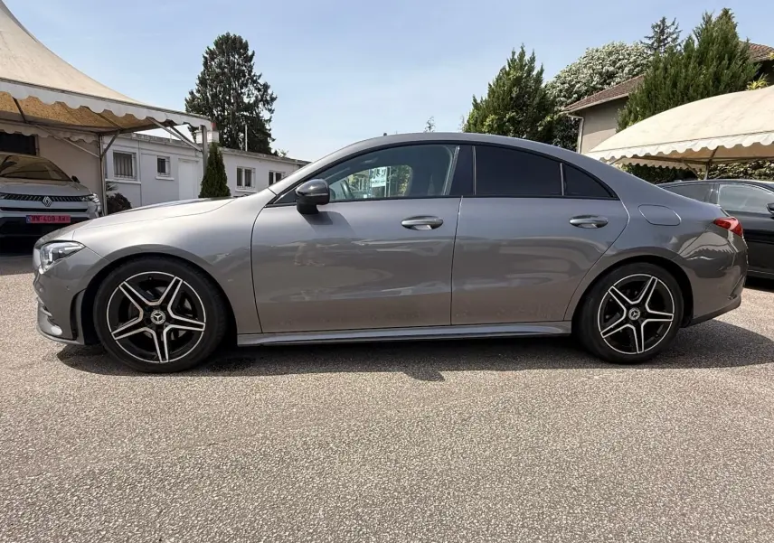 Vue de profil côté gauche d'une Mercedes Classe CLA 180 D AMG Line gris montagne avec jantes alliage noires et détails chromés.