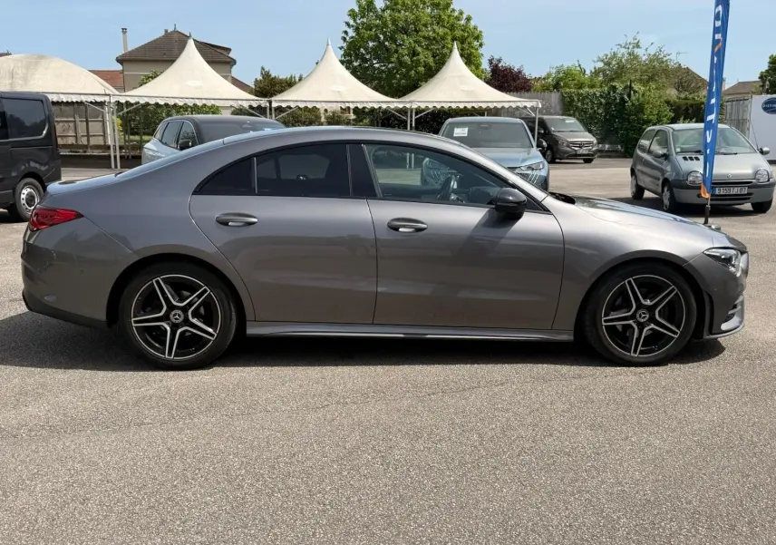 Vue de profil côté gauche d'une Mercedes Classe CLA 180 D AMG Line gris montagne avec jantes alliage noires.