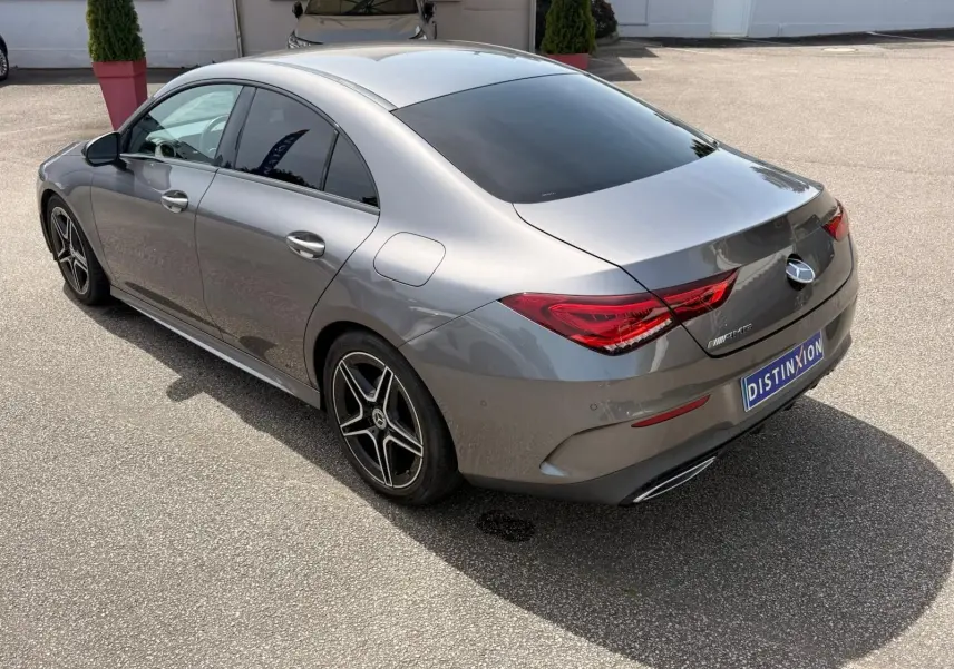 Vue 3/4 arrière droite d'une Mercedes Classe CLA 180 D AMG Line gris montagne avec jantes AMG et vitres teintées.