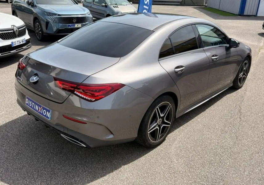 Vue 3/4 arrière droite d'une Mercedes Classe CLA 180 D AMG Line gris montagne avec jantes alliage noires et vitres teintées.