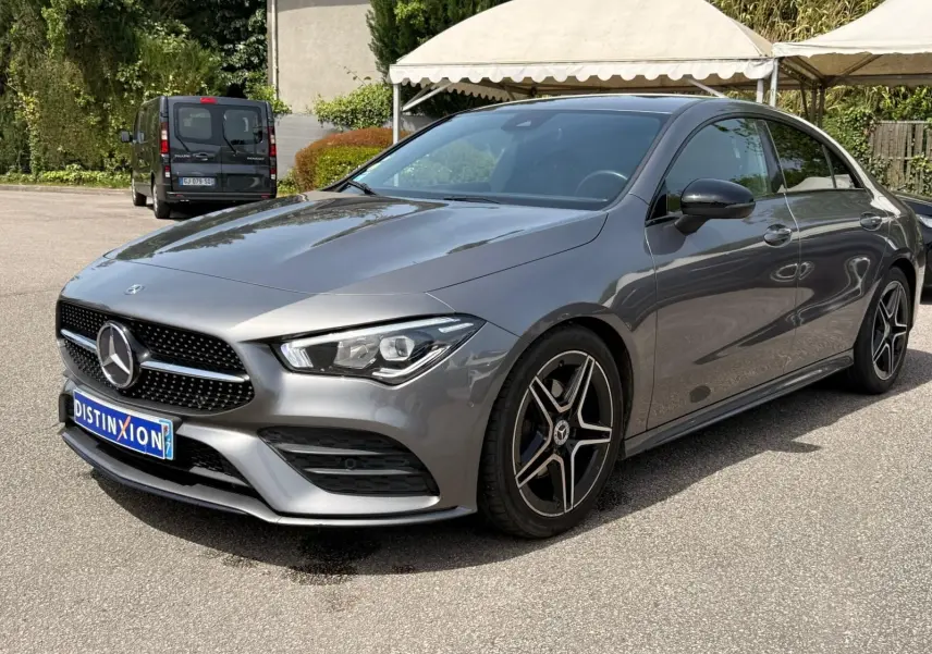 Vue 3/4 avant droit d'une Mercedes Classe CLA 180 D AMG Line gris montagne avec jantes étoile et calandre noire distinctive.