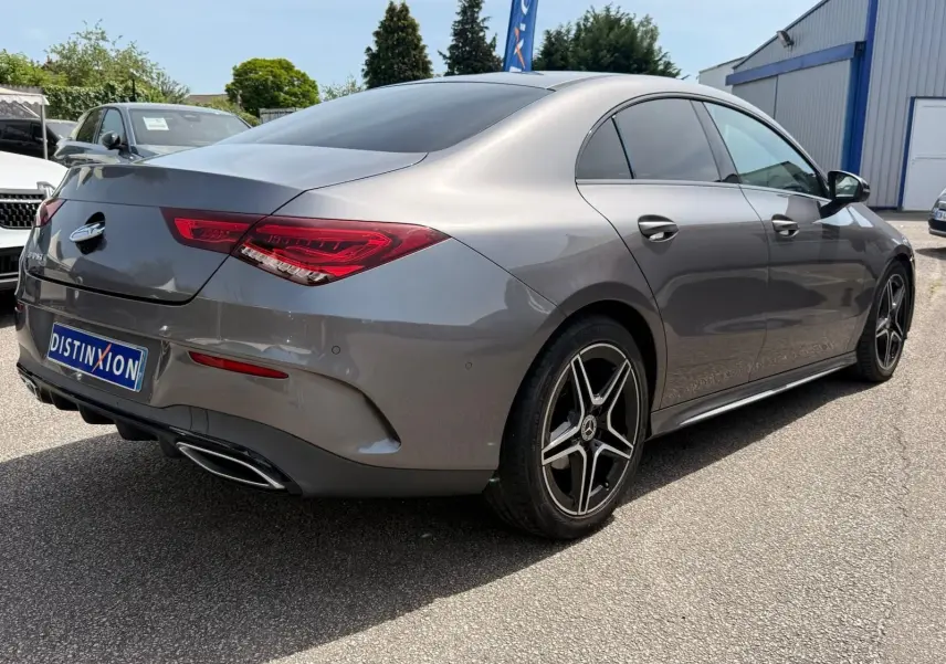 Vue 3/4 arrière droite d'une Mercedes Classe CLA 180 D AMG Line gris montagne avec jantes alliage et feux LED distinctifs.