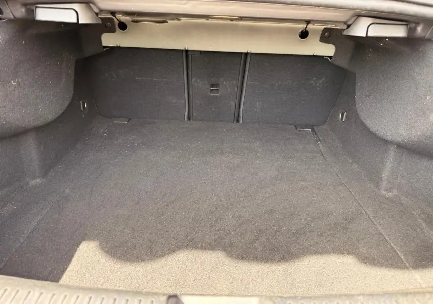 Coffre vide vu de face d’une Mercedes Classe CLA 180 D AMG Line gris montagne, intérieur en tissu noir.