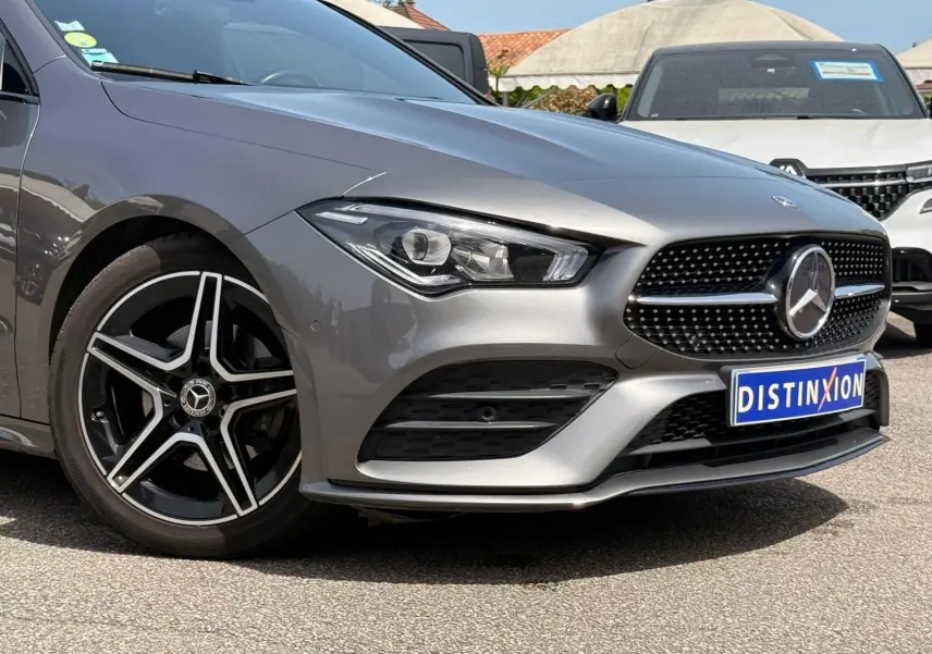 Vue 3/4 avant gauche d'une Mercedes Classe CLA 180 D AMG Line gris montagne avec jantes cinq branches noires et grises.
