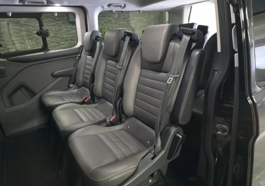 Vue intérieure côté droit sur les sièges en cuir gris anthracite du Ford Transit Fourgon Custom 2022 noir.