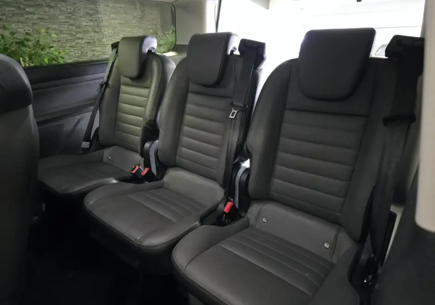 Vue intérieure sur la rangée arrière de trois sièges individuels en cuir gris anthracite du Ford Transit Custom noir.