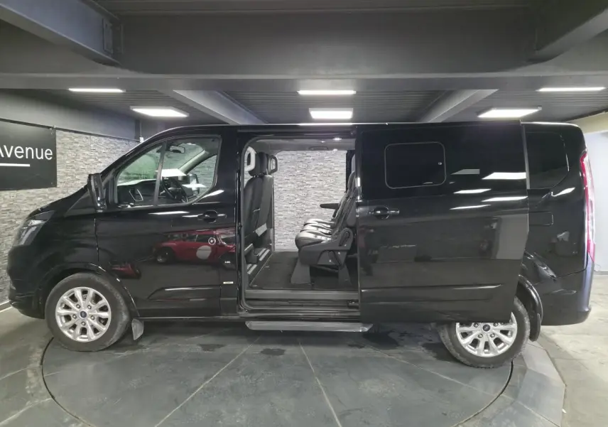 Vue de profil côté gauche d'un Ford Transit Fourgon noir 2022 avec porte coulissante ouverte et sièges passagers visibles.