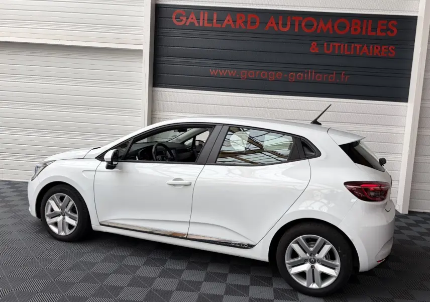 Profil droit d'une Renault Clio Business E-Tech hybride blanche 2022, avec jantes alliage et vitres teintées.