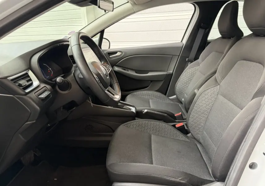 Vue intérieure côté conducteur de la Renault Clio Business E-Tech hybride 2022, sièges tissu gris et volant multifonctions cuir synthétique.