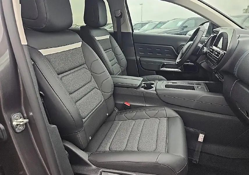Vue intérieure côté conducteur du Citroën C5 Aircross gris 2025, sièges en cuir et tissu avec console centrale visible.