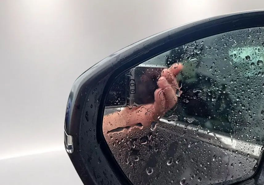 Rétroviseur droit gris du Citroën C5 Aircross 2025 avec gouttes d'eau et reflet partiel de la carrosserie.