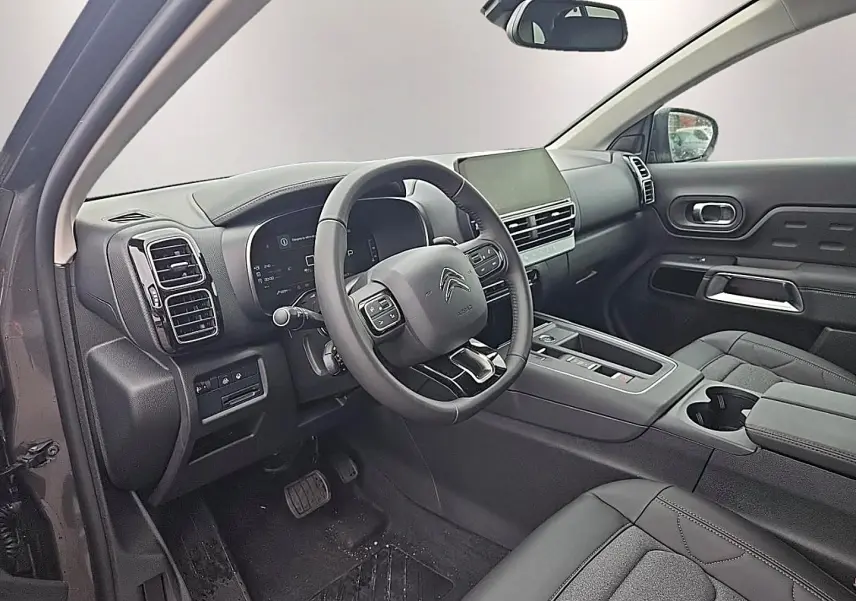 Vue intérieure côté conducteur du Citroën C5 Aircross gris, volant cuir multifonction et écran tactile central visible.