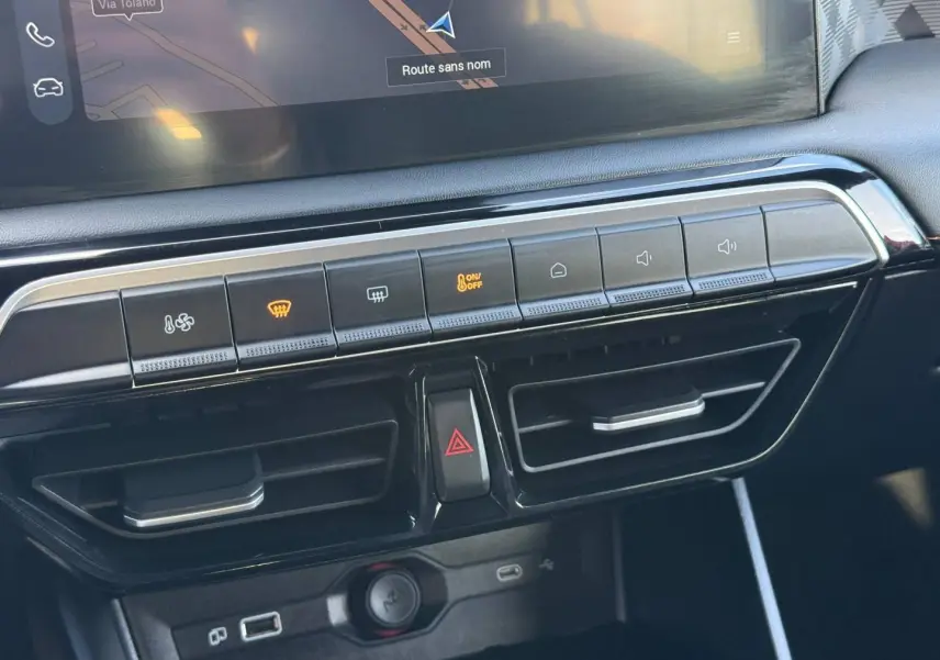 Vue rapprochée de la console centrale du MG3 2025, boutons de climatisation et prises USB visibles, finition noire brillante.