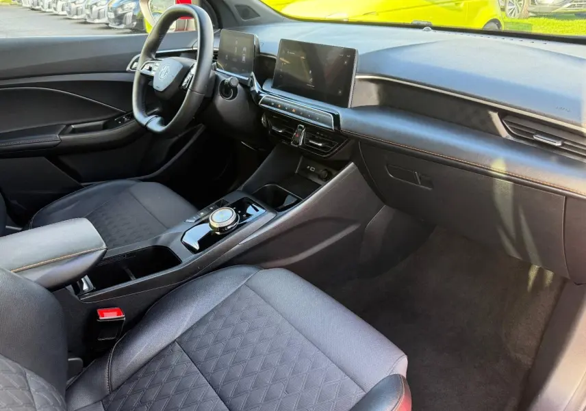Vue intérieure côté conducteur du MG3 1.5 Hybrid+ 195ch Luxury, avec sièges noir simili/tissu et écran tactile central.