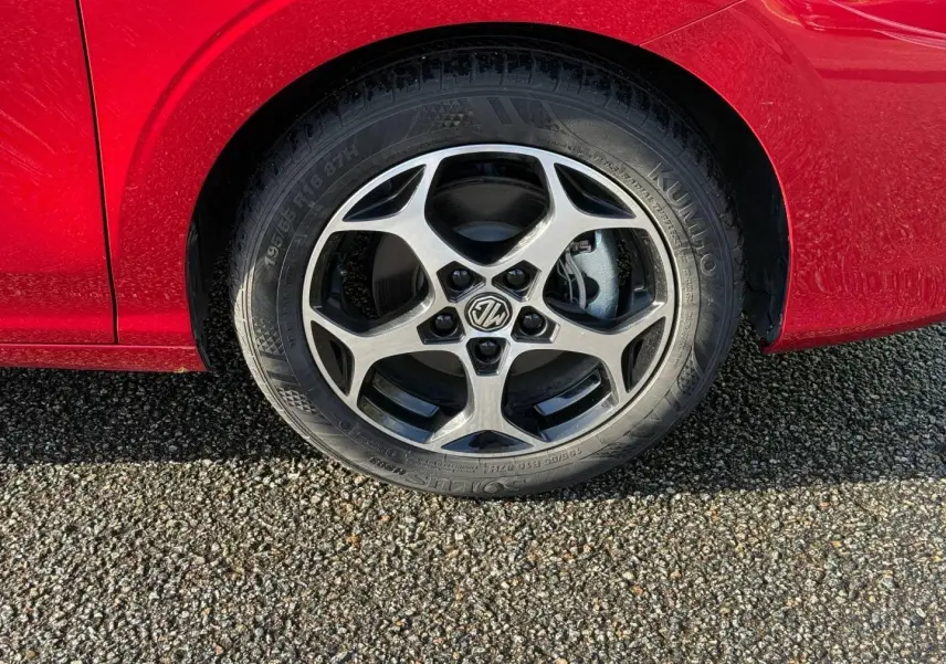 Gros plan sur la roue avant droite avec jante alu cinq branches du MG3 1.5 Hybrid+ Diamond Red métallisé.