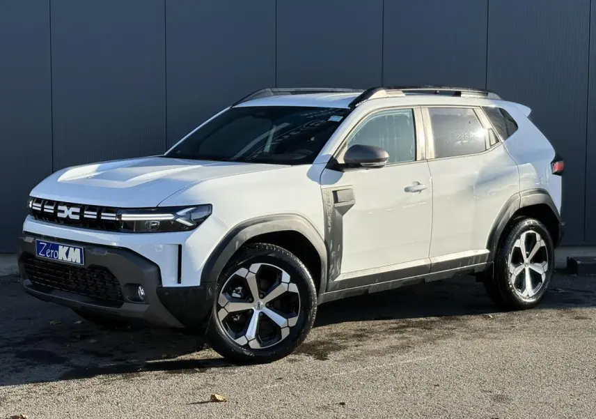 Vue 3/4 avant droit du Dacia Duster blanc glacier avec jantes alliage 18 pouces et barres de toit noires.