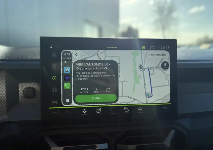 Écran tactile central du Dacia Duster blanc glacier 2025 affichant la navigation connectée avec itinéraire en cours.