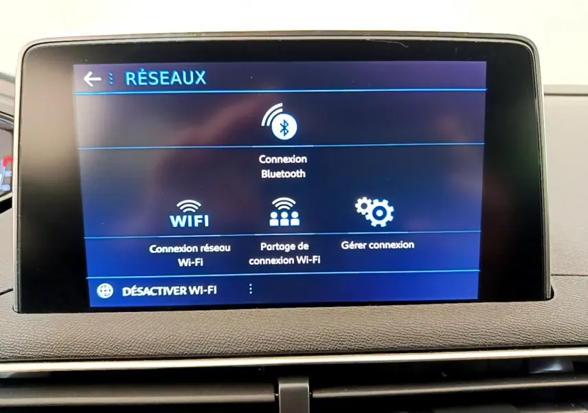 Écran tactile central affichant les options réseau Wi-Fi et Bluetooth dans le tableau de bord du Peugeot 3008.
