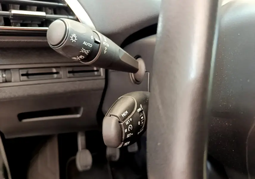 Gros plan sur les commandes au volant cuir du côté gauche du Peugeot 3008 gris foncé Puretech 130 S&S ACTIVE 2020.