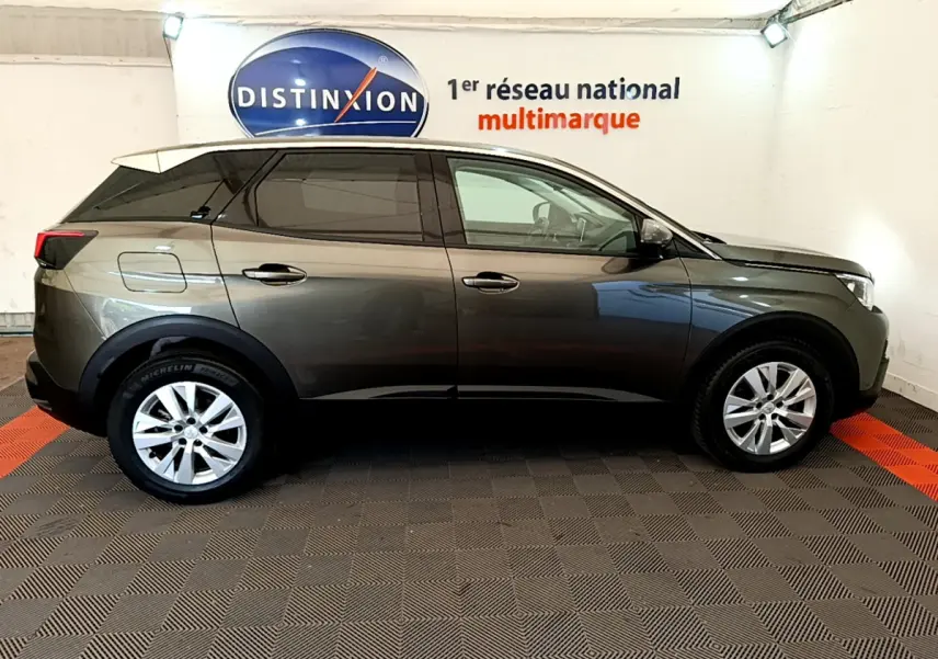 Profil latéral droit d'un Peugeot 3008 gris foncé 2020 dans un showroom avec logo Distinxion en arrière-plan.