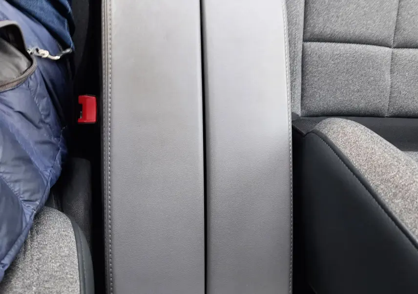 Vue rapprochée de l'accoudoir central en cuir gris entre les sièges tissu gris du Citroën C5 Aircross 2020.