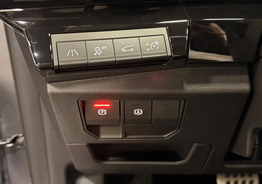 Gros plan sur les commandes de sécurité et d'assistance du tableau de bord du Renault Austral gris schist avec toit noir.