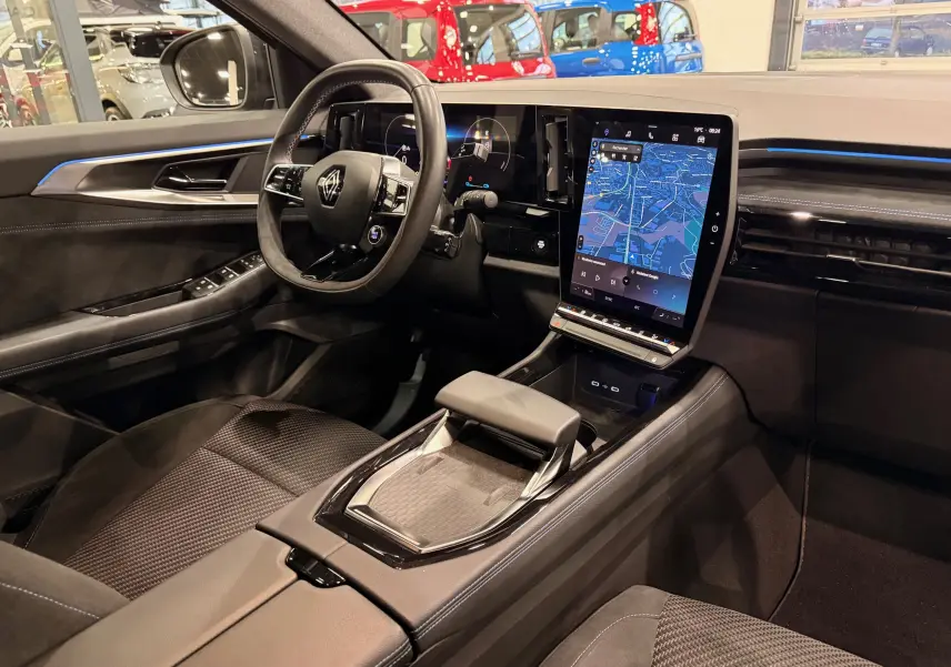 Vue intérieure côté conducteur du Renault Austral E-Tech 2023, avec tableau de bord numérique et écran tactile central lumineux.