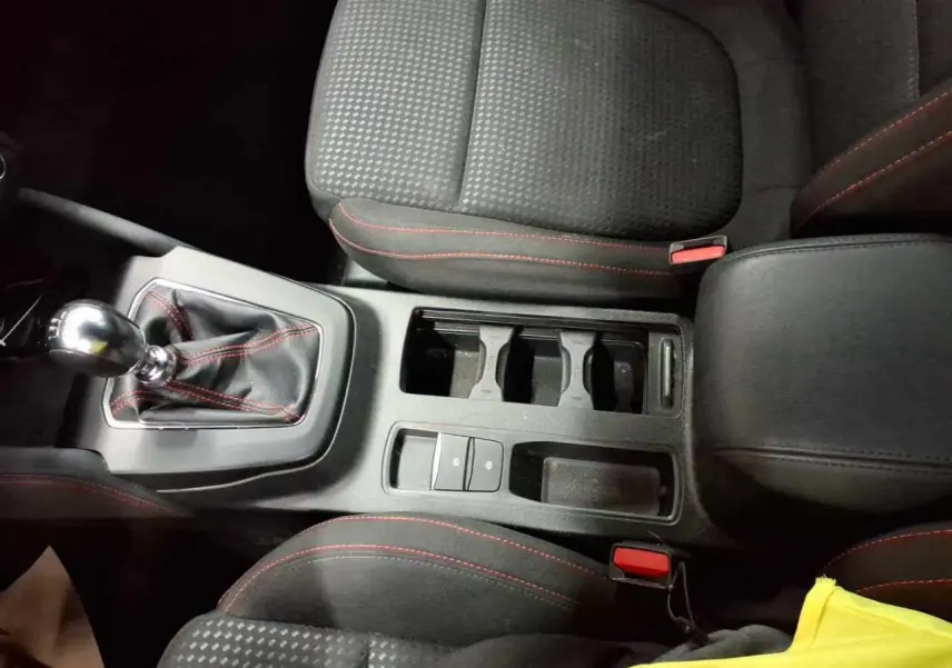 Vue plongeante sur la console centrale et les sièges noirs avec surpiqûres rouges de la Ford Focus SW EcoBoost MHEV 2023.