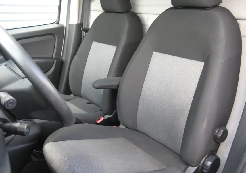 Vue intérieure rapprochée des sièges avant gris et noirs du Fiat Doblo Cargo 2018, avec accoudoir côté droit.
