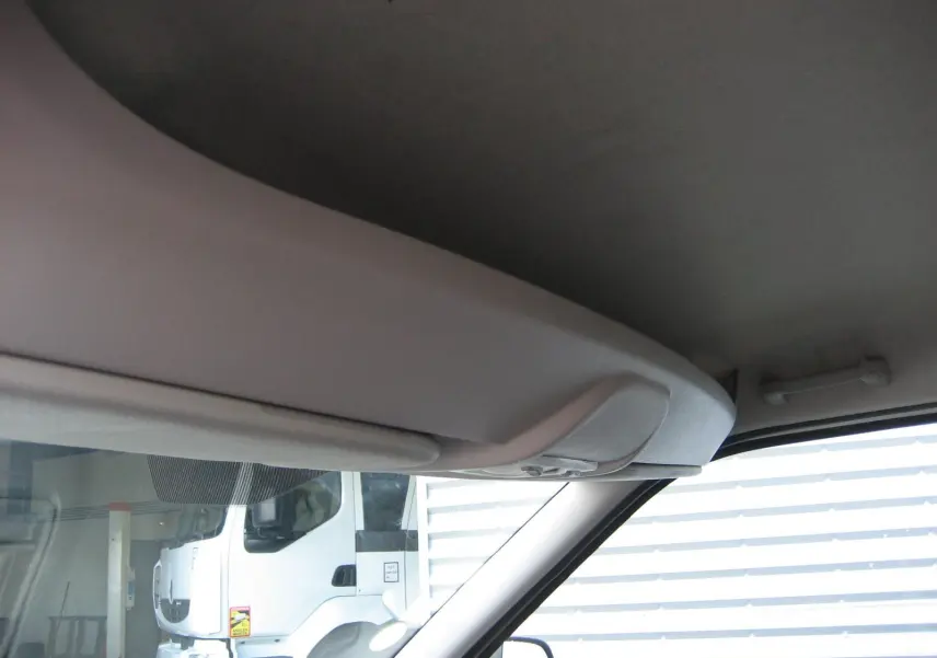 Vue intérieure côté passager du Fiat Doblo Cargo blanc 2018, montrant le plafond et pare-brise avec reflet extérieur.