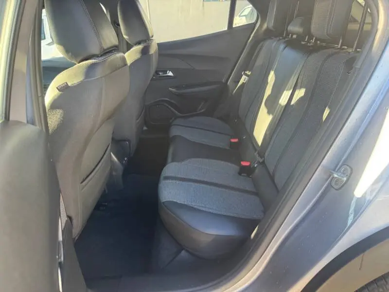 Vue intérieure côté gauche des sièges arrière gris du Peugeot 2008 Hybrid 136 e-DCS6 Allure 2025 avec ceintures et appuie-têtes.