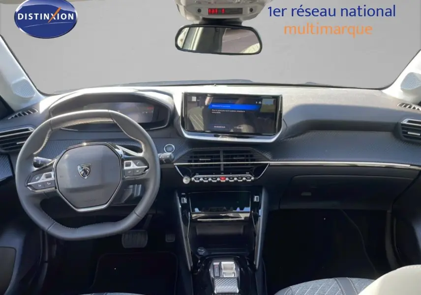 Intérieur de la Peugeot 208 Hybrid blanc Okenite, vue frontale du tableau de bord avec écran tactile et volant multifonction.