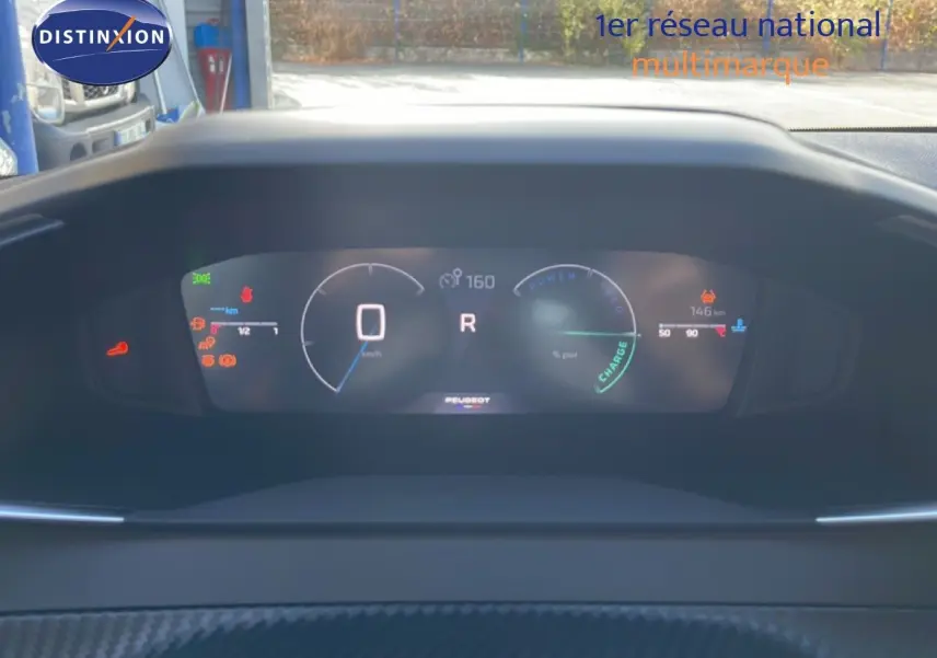 Tableau de bord numérique de Peugeot 208 Hybrid blanc, affichant vitesse et indicateurs en vue frontale.