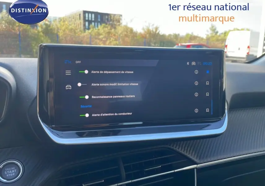 Vue intérieure centrée sur l'écran tactile du tableau de bord de la Peugeot 208 Hybrid 110ch Allure, avec affichage des alertes de sécurité.