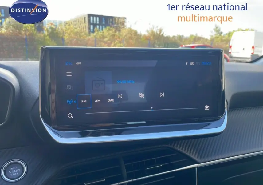 Écran tactile central du tableau de bord de la Peugeot 208 hybride blanc Okenite, vue intérieure avant.