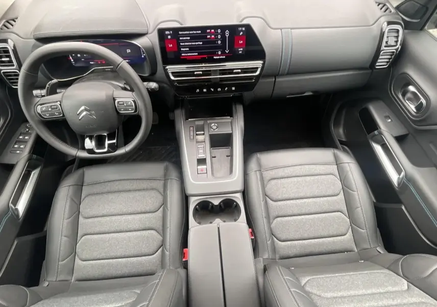 Vue intérieure de face du poste de conduite du Citroën C5 Aircross 2025 avec sièges cuir et écran tactile central.