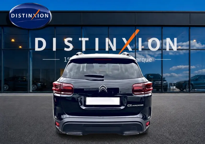 Vue arrière d'un Citroën C5 Aircross noir 2025, avec feux LED et barres de toit visibles devant une vitrine Distinxion.