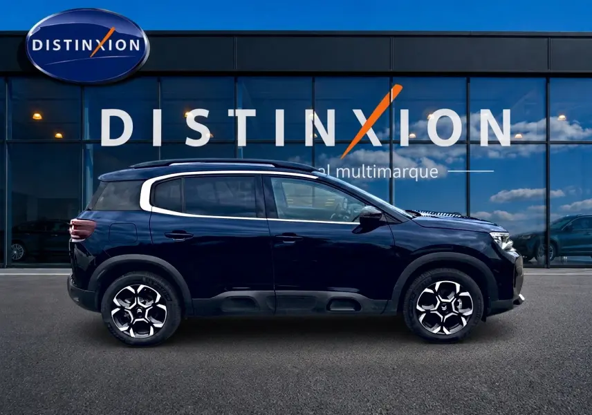 Profil latéral droit du Citroën C5 Aircross noir 2025 avec barres de toit et jantes alu distinctives.