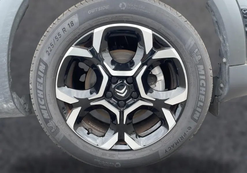 Gros plan sur la jante alu noire et argentée de 18 pouces avec pneu Michelin d’un Citroën C5 Aircross noir.