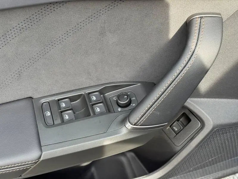 Détail de la commande des vitres et du rétroviseur côté gauche en cuir gris avec surpiqûres marron sur une CUPRA Formentor 2026.