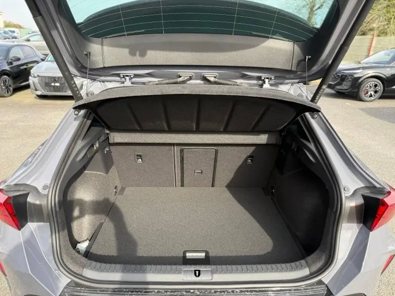 Coffre ouvert vu de l'arrière d'une CUPRA Formentor 2.0 TDI gris Graphène personnalisé, espace de chargement spacieux et propre.