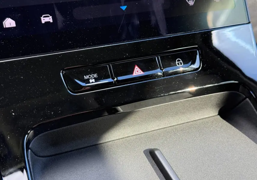 Gros plan sur la console centrale noire brillante du JAECOO J5 avec boutons mode, warning et verrouillage.