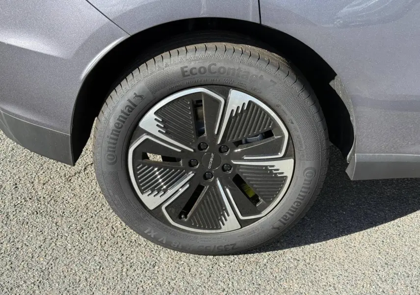 Gros plan sur la roue arrière droite du JAECOO J5 Phantom Grey métal avec jante alu au design moderne noir et argent.