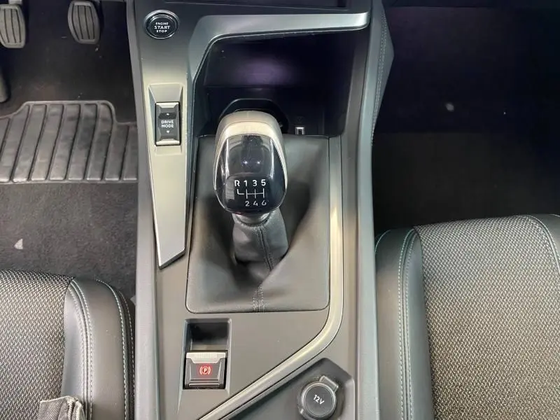 Vue rapprochée de la console centrale de la Peugeot 308 gris Artense avec levier de vitesses manuel et bouton start/stop.