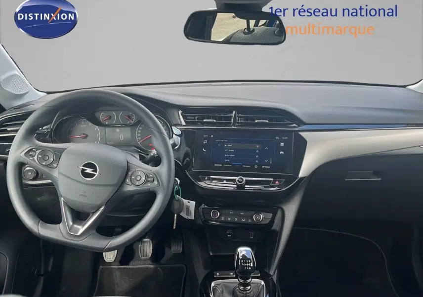 Vue intérieure avant de l'Opel Corsa 2025 avec volant multifonction, tableau de bord moderne et levier de vitesse manuel.