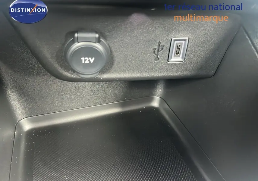 Prise 12V et port USB en gros plan dans l'habitacle de l'Opel Corsa bleu Voltaik Metal, version 2025.