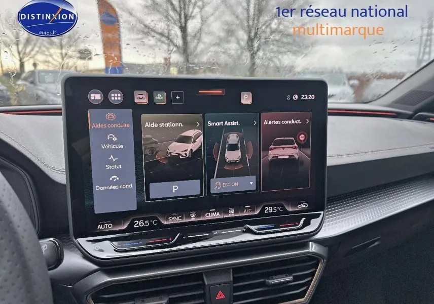 Intérieur de la CUPRA LEON ST 2025 montrant l'écran tactile central avec aides à la conduite sous pluie.